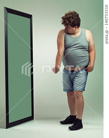 Man, flex and body image in mirror for eating disorder, anxiety and mental health. Depression, weight gain and insecurity for plus size male person, reflection and muscle and frustrated or sad Man, flex and body image in mirror for eating disorder, anxiety and mental health. Depression, weight gain and insecurity for plus size male person, reflection and muscle and frustrated or sad 140753510