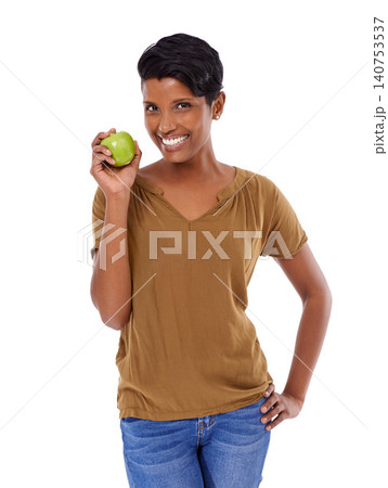 Woman, portrait and smile in studio with apple for nutrition, healthy diet and wellness on white background. Model, indian person or face with fruit for vitamin c, fiber or lose weight with happiness 140753537