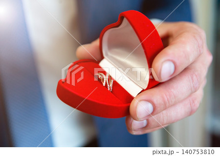 wedding rings in hand. wedding rings in the hands of the groom. wedding rings in hand. wedding rings in the hands of the groom. 140753810