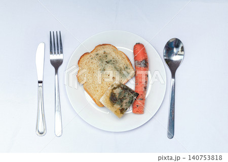 Food served on a white plate with a slice of bread, carrot, and a piece of jelly Food served on a white plate with a slice of bread, carrot, and a piece of jelly 140753818