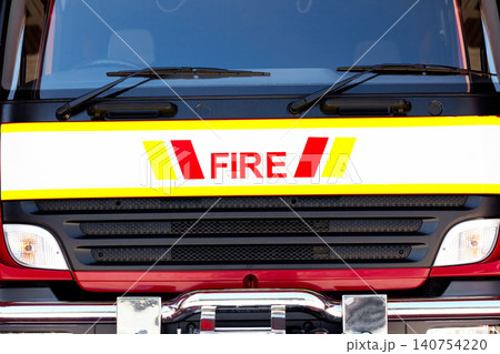 Closeup, fire truck and emergency service with front, safety and occupation with rescue and grill. City vehicle, transportation for response and window with protection, engine and travel with symbol Closeup, fire truck and emergency service with front, safety and occupation with rescue and grill. City vehicle, transportation for response and window with protection, engine and travel with symbol 140754220