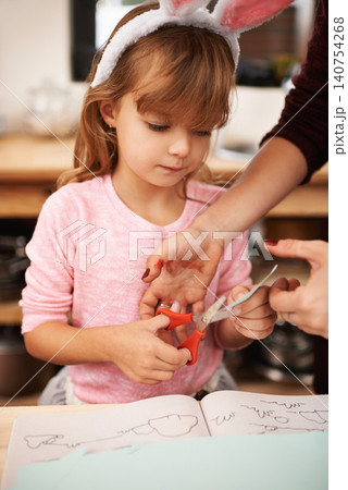 Little girl, bunny ears and cutting paper with scissors for arts and crafts, class project or decor. Closeup of child or kid with pattern, outline or shape in artwork for easter holiday at school Little girl, bunny ears and cutting paper with scissors for arts and crafts, class project or decor. Closeup of child or kid with pattern, outline or shape in artwork for easter holiday at school 140754268