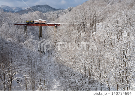 雪化粧した森と芦別橋梁を渡る列車の冬景色 140754694