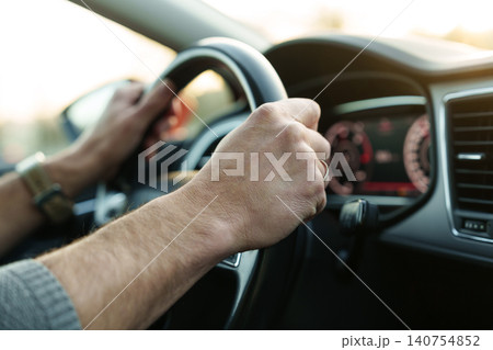 Male hands holding steering wheel while driving Male hands holding steering wheel while driving 140754852