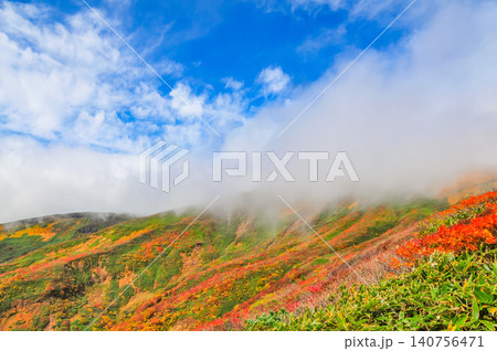 秋の晴れ間 紅葉最盛期の栗駒山・雲間から青空覗く全山紅葉の美しい山肌風景 秋の晴れ間 紅葉最盛期の栗駒山・雲間から青空覗く全山紅葉の美しい山肌風景 140756471