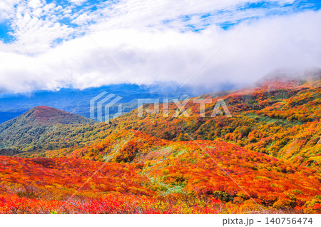 秋の晴れ間 紅葉最盛期の栗駒山・雲間から青空覗く全山紅葉の美しい山肌風景 秋の晴れ間 紅葉最盛期の栗駒山・雲間から青空覗く全山紅葉の美しい山肌風景 140756474