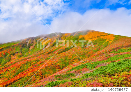 秋の晴れ間 紅葉最盛期の栗駒山・雲間から青空覗く全山紅葉の美しい山肌風景 秋の晴れ間 紅葉最盛期の栗駒山・雲間から青空覗く全山紅葉の美しい山肌風景 140756477
