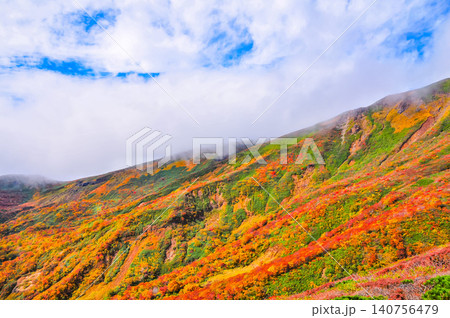 秋の晴れ間 紅葉最盛期の栗駒山・雲間から青空覗く全山紅葉の美しい山肌風景 秋の晴れ間 紅葉最盛期の栗駒山・雲間から青空覗く全山紅葉の美しい山肌風景 140756479