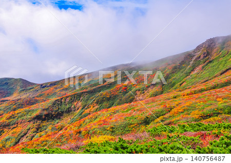 秋の晴れ間 紅葉最盛期の栗駒山・雲間から青空覗く全山紅葉の美しい山肌風景 秋の晴れ間 紅葉最盛期の栗駒山・雲間から青空覗く全山紅葉の美しい山肌風景 140756487