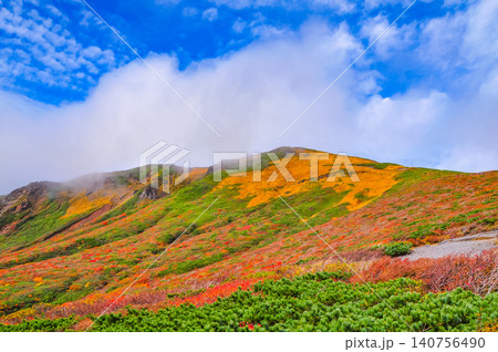 秋の晴れ間 紅葉最盛期の栗駒山・雲間から青空覗く全山紅葉の美しい山肌風景 秋の晴れ間 紅葉最盛期の栗駒山・雲間から青空覗く全山紅葉の美しい山肌風景 140756490