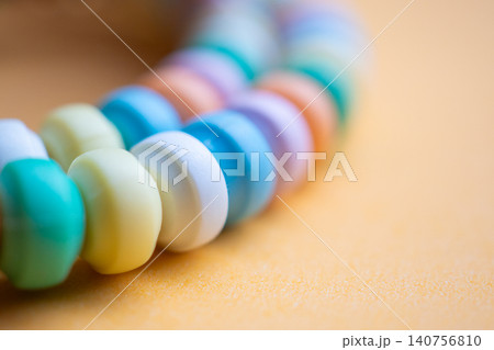 Colorful beaded bracelet close up on orange background Colorful beaded bracelet close up on orange background 140756810
