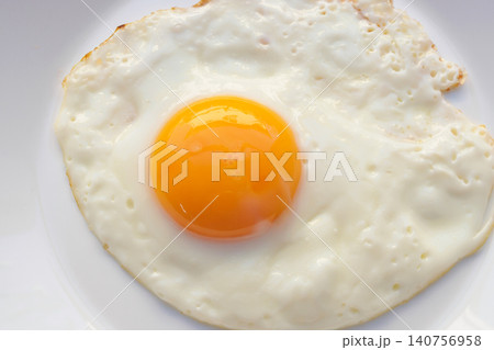 Fried egg on white dish close up 140756958