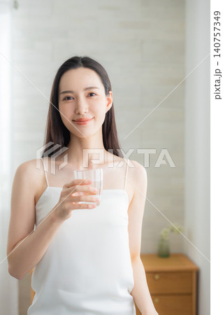 窓辺で水を飲む若い女性 窓辺で水を飲む若い女性 140757349