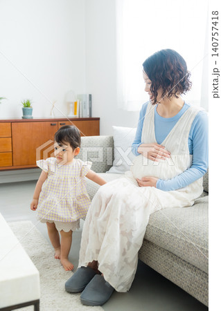 1歳の女の子を抱っこする妊婦のお母さん 1歳の女の子を抱っこする妊婦のお母さん 140757418