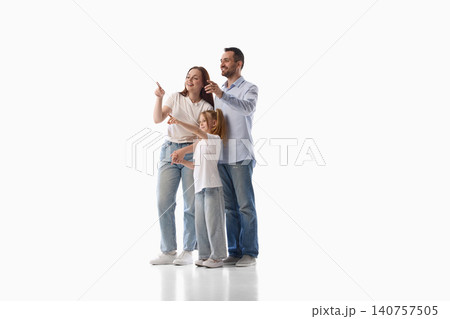 Happy family pointing forward together on white studio background Happy family pointing forward together on white studio background 140757505