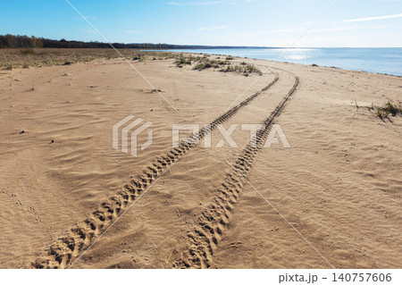 Turning all-terrain vehicle tracks goes across the sandy beach Turning all-terrain vehicle tracks goes across the sandy beach 140757606