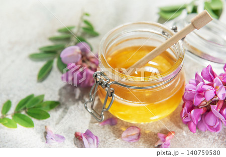 Honey and honey dipper with acacia flowers 140759580