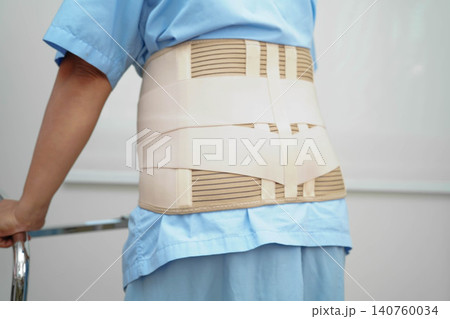 Asian woman wearing lumbar support pain back and use walker in hospital. Asian woman wearing lumbar support pain back and use walker in hospital. 140760034