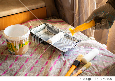 Hand dipping roller into paint tray. Spring home refresh. Budget friendly transformation. Small improvements, big mood boost. Smart spending Hand dipping roller into paint tray. Spring home refresh. Budget friendly transformation. Small improvements, big mood boost. Smart spending 140760500