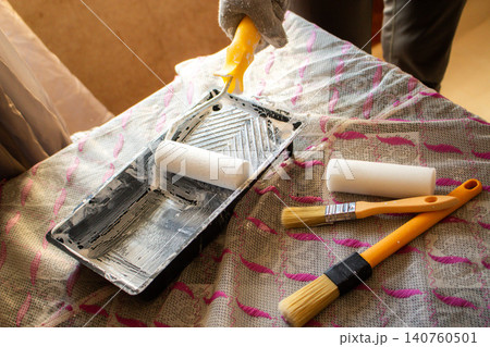 DIY roller with fresh paint. Tray, sleeve, extension pole. Affordable tools, big results. Developing handy skills. Smart budget move for cosmetic home repairs 140760501