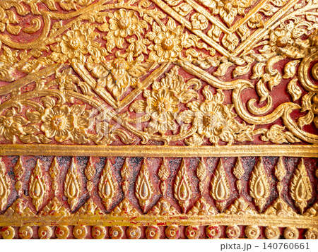 Traditional Thai golden stucco floral pattern on red wall background. Traditional Thai golden stucco floral pattern on red wall background. 140760661