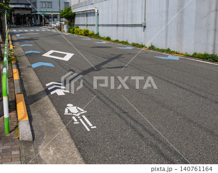 車道の左端に設置された自転車ナビマーク(白色)と自転車ナビライン(青色) 車道の左端に設置された自転車ナビマーク(白色)と自転車ナビライン(青色) 140761164