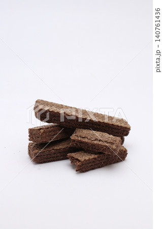 Stack of chocolate wafers rests on clean white background. No people appear in this image. Simple, sweet, and tempting snack for all. Perfect for food blogs, menus, or advertising Stack of chocolate wafers rests on clean white background. No people appear in this image. Simple, sweet, and tempting snack for all. Perfect for food blogs, menus, or advertising 140761436