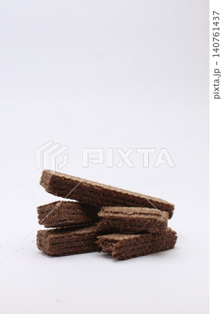 Stack of chocolate wafers rests on clean white background. No people appear in this image. Simple, sweet, and tempting snack for all. Perfect for food blogs, menus, or advertising Stack of chocolate wafers rests on clean white background. No people appear in this image. Simple, sweet, and tempting snack for all. Perfect for food blogs, menus, or advertising 140761437
