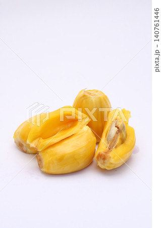 Fresh jackfruit halves rest on a clean white surface. Golden flesh reveals soft, fibrous interior. The fruit's outer skin is textured and slightly wrinkled. No people appear in the image Fresh jackfruit halves rest on a clean white surface. Golden flesh reveals soft, fibrous interior. The fruit's outer skin is textured and slightly wrinkled. No people appear in the image 140761446