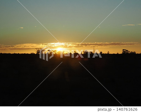 夕陽が地平線に沈む車窓風景—木々の帯が光を受け止める静かな瞬間 夕陽が地平線に沈む車窓風景—木々の帯が光を受け止める静かな瞬間 140761626