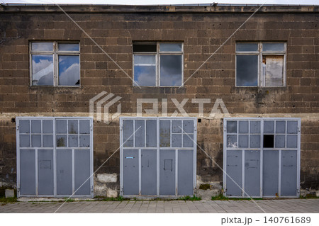 Rustic industrial building with decayed windows and metal shutters Rustic industrial building with decayed windows and metal shutters 140761689