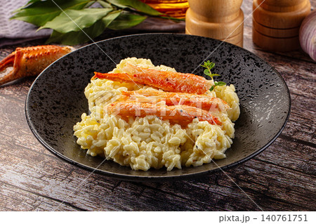 Creamy risotto with crab claws in dark speckled bowl on rustic wood Creamy risotto with crab claws in dark speckled bowl on rustic wood 140761751
