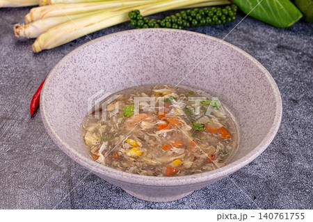 Bowl of clear chicken soup with vegetables and herbs on dark surface Bowl of clear chicken soup with vegetables and herbs on dark surface 140761755