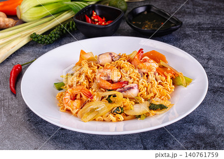 Spicy seafood noodle dish with shrimp and squid on white plate Spicy seafood noodle dish with shrimp and squid on white plate 140761759