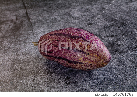 Purple speckled exotic fruit on textured gray surface Purple speckled exotic fruit on textured gray surface 140761765