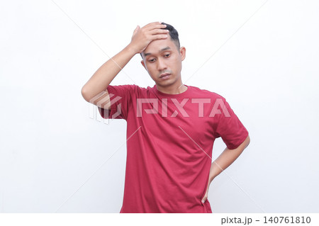 Man shrugs, hands open, showing uncertainty. He wears a simple red tshirt. His expression suggests confusion or indifference. Ideal for situations requiring a gesture of hesitation 140761810