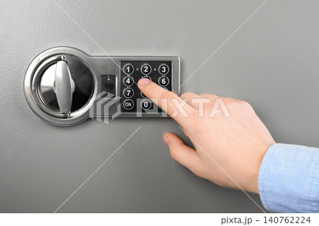 Man opening steel safe with electronic combination lock, closeup 140762224