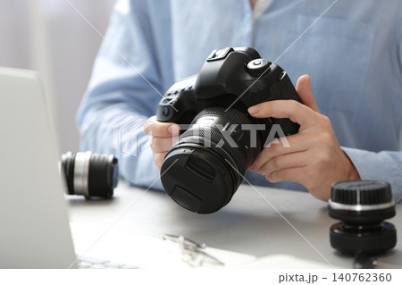 Journalist with camera working at table, closeup Journalist with camera working at table, closeup 140762360