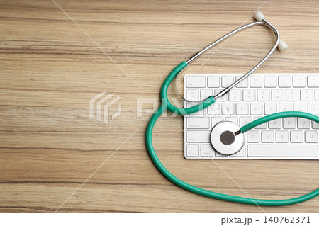 Keyboard and stethoscope on wooden table, flat lay with space for text. Concept of technical support 140762371