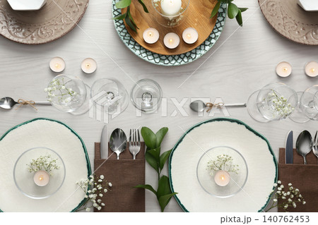 Elegant table setting with green plants on white wooden background, flat lay Elegant table setting with green plants on white wooden background, flat lay 140762453