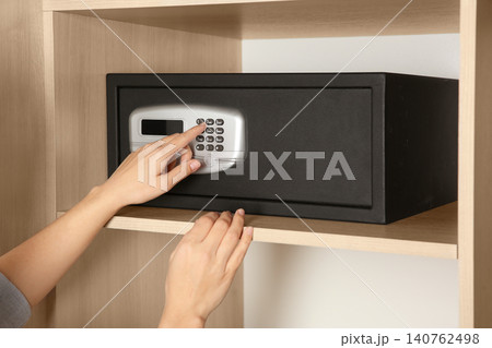 Woman opening black steel safe with electronic lock at hotel, closeup 140762498