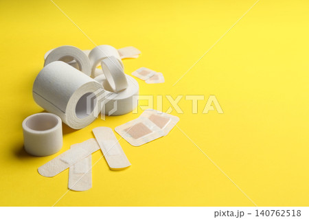 Different types of sticking plasters on yellow background. Space for text Different types of sticking plasters on yellow background. Space for text 140762518