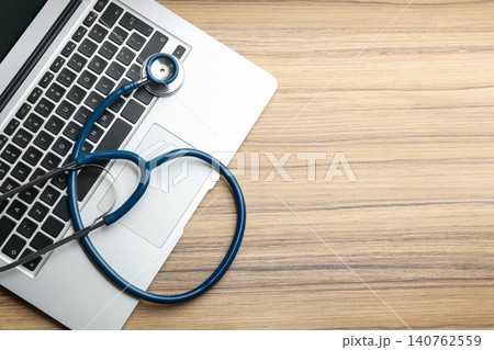 Laptop and stethoscope on wooden table, flat lay with space for text. Concept of technical support 140762559