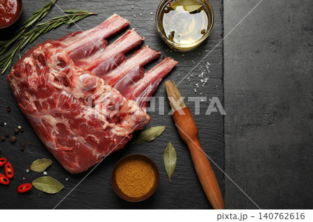 Raw ribs with herbs and spices on grey table, flat lay Raw ribs with herbs and spices on grey table, flat lay 140762616