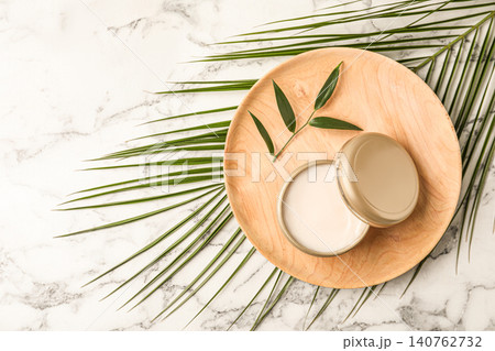 Cosmetic product and leaves on white marble table, top view. Space for text Cosmetic product and leaves on white marble table, top view. Space for text 140762732