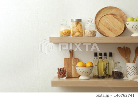 Wooden shelves with dishware and products on white wall. Kitchen interior idea Wooden shelves with dishware and products on white wall. Kitchen interior idea 140762741