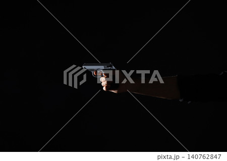 Professional killer with gun on black background, closeup Professional killer with gun on black background, closeup 140762847