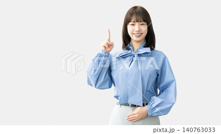人差し指を立てて案内する若い女性・ビジネスウーマン 人差し指を立てて案内する若い女性・ビジネスウーマン 140763033