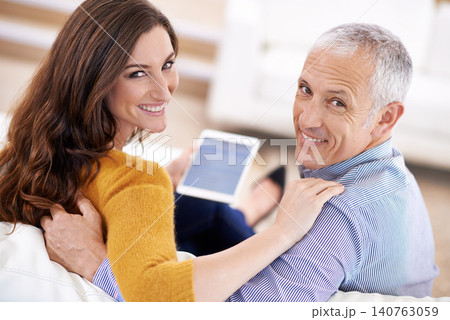 Couple, portrait and smile with tablet on sofa with hug for bonding, screen and relax with social media or internet. Senior man, woman or face with digital display for subscription or embrace in home 140763059