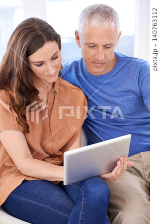 Couple, tablet and relax on couch in home with reading, search and app to watch movie with bonding. People, woman and mature man on digital touchscreen for notification with web connection in house Couple, tablet and relax on couch in home with reading, search and app to watch movie with bonding. People, woman and mature man on digital touchscreen for notification with web connection in house 140763112